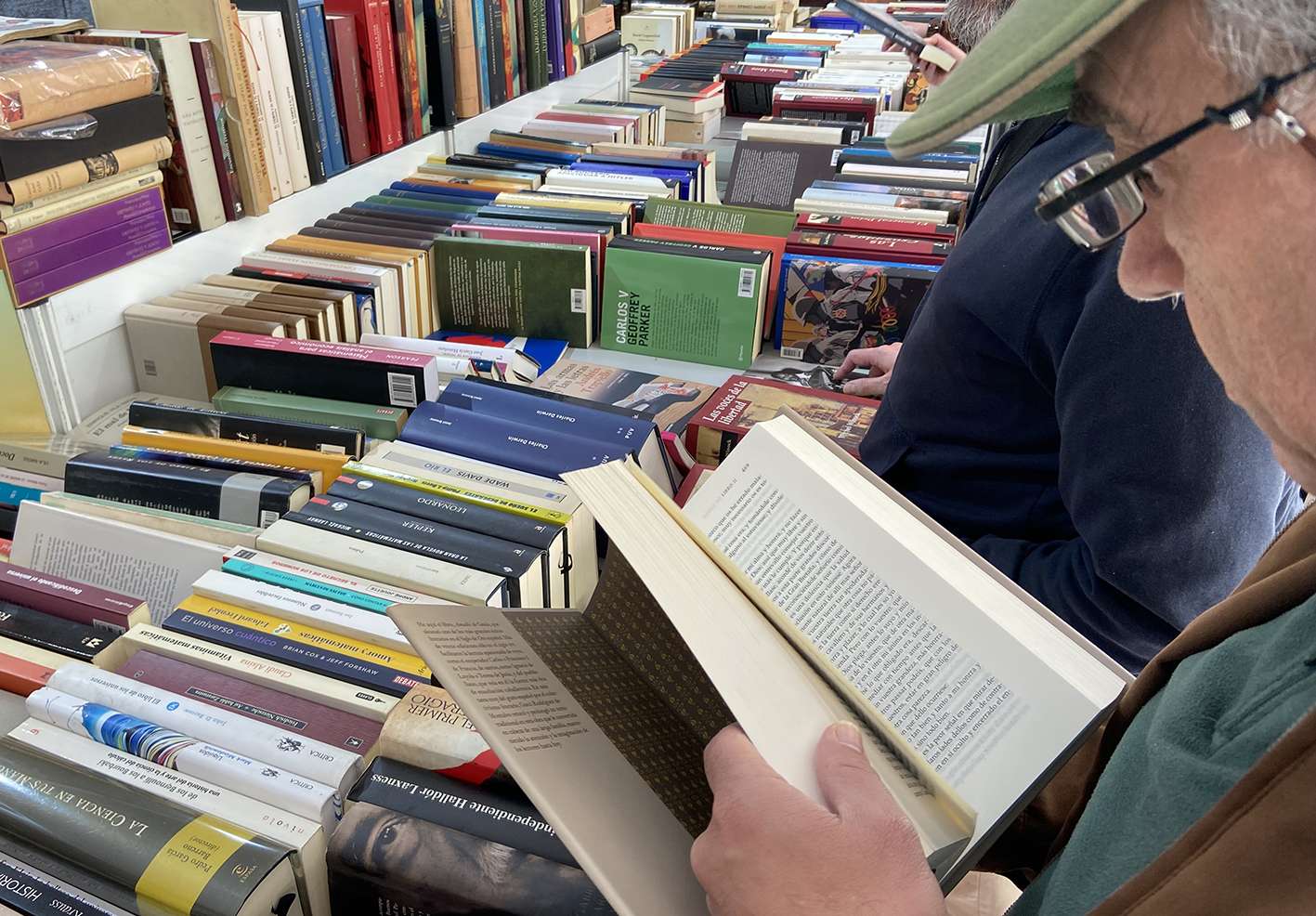 Señor hojeando un libro en la feria